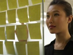 CU Woman looking at adhesive notes on office board and smiling / China Stock Footage