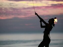 MS Woman poi dancer performing with fireballs in front of pool with reflection of his silhouette in pool at sunrise / Montezuma, Costa Rica Stock Footage