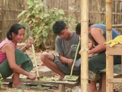 MS Woman and man removing skin and ends of sugarcane sticks with small machetes /  Vang Vieng, Vientiane, Laos Stock Footage