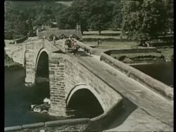 Traditional old Welsh stone and slate farmhouse. Family, in national costume, go to the Eisteddford Festival in horse and cart. Bards processing and crowds singing at the festival. Wales, 1957 Stock Footage