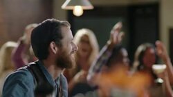 Bartender smiles and shakes cocktail in crowded bar Stock Footage