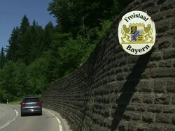 MS Cars passing through street near sign board  / Kornau, Barvaria, Germany Stock Footage