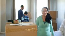 Happy family moving boxes into their new home Stock Footage