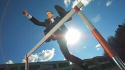 HD Super Slow-Mo: Businessman Jumping Over A Hurdle Stock Footage