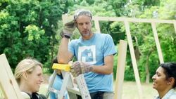 Volunteer on ladder inspecting wood planks at construction site Stock Footage