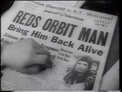 B/W 1961 close up hand on newspaper with "Reds Orbit Man" headline + photo of Yuri Gagarin Stock Footage