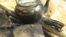 panning: Steaming tea kettle  by traditional method and adding wooden fire Stock Footage