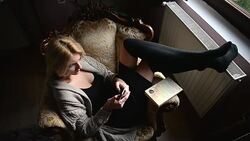 Woman sitting in armchair and using phone Stock Footage