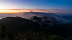 clouds or mist moving fast over mountain peak in the morning with sun light in 4K UHD. Stock Footage