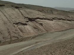 A parched riverbed surrounded by an impressive hillside landscape. Stock Footage