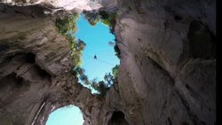 Man traverses highline stretched above deep canyon,gorge Stock Footage