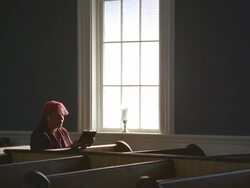 WS Senior woman praying in church near window / Port Gamble, Washington State, USA Stock Footage