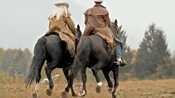 SLO MO DS Male and female rancher riding galloping horses Stock Footage
