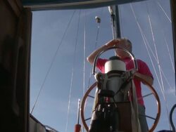 MS Older man looking out to sea from behind steering wheel of his sail boat / Wismar, Mecklenburg-Vorpommern, Germany Stock Footage