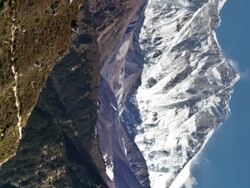 Vertical shot of Time-lapse of Everest and surrounding peaks and people on a foreground trail. Stock Footage