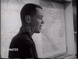 1965: USS ENTERPRISE (CVN-65) BRIEFING: VS Pilots in briefing room, holding coffee mugs, looking over paperwork in notebooks, standing male pointing to Vietnam wall map, sitting in high back chairs listening.   Cold War, conflict, combat cruise. Instructional Video