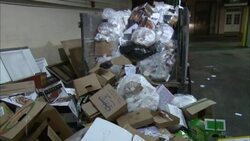 A dumpster overflows with plastic bags, cardboard and other trash. Stock Footage