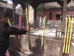 A monk adds long incense sticks to a temple trough in Beijing. Stock Footage