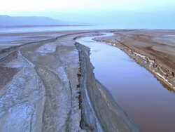 Aerial river meets the Dead Sea in the Judea Desert, Israel Stock Footage