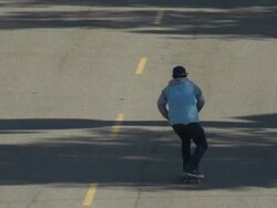 A young man skateboarding in the middle of the street. - Slow Motion Stock Footage