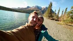 Cheerfull travellers taking selfies by lake Stock Footage