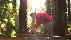 A young women running, working out, stretching and checking her mobile device outdoors on a sunny day. Stock Footage