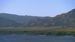 Death Valley Desert Pan to the Amargosa River with Red Mountains Stock Footage