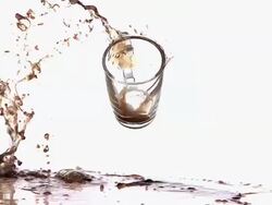 MS SLO MO Shot of coffee spilling and splashing after falling cup of coffee / Vieux Pont, Normandy, France Stock Footage