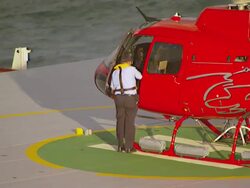 MS AERIAL View of pilot getting down from helicopter and walking on cargo helipad / Queensland, Australia Stock Footage