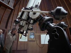 Low angle wide shot boy, father and grandfather looking through telescope at observatory Stock Footage