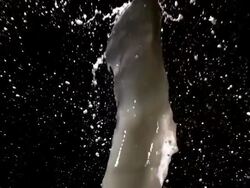 CU SLO MO Shot of Milk splashing against black background / Calvados, Normandy, france Stock Footage