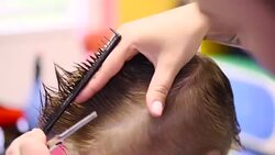 Hairdresser cutting cute childs hair Stock Footage
