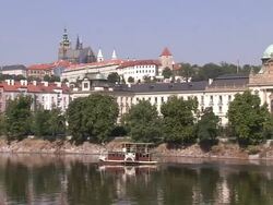 Wide Shot static-Domed buildings overlook a ferry on a river. / Prague, Czech Republic Stock Footage
