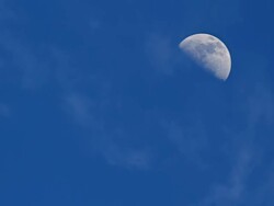 MS Shot of Quarter Moon and clouds moving across blues sky / Polihe Beach, Kauai Hawaii, United States Stock Footage