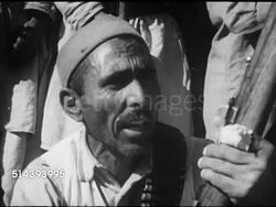 1953: THE KHYBER PASS: VS Local Pashtuns (Pathans) tribesmen standing, sitting hillside, men talking (No SOT), VS Unidentified celebration, dancers dancing in street to drums, people watching, dancers w/ swords.    Pakistan, Afghanistan, Instructional Video