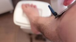man shaving his legs with trimmer . Stock Footage