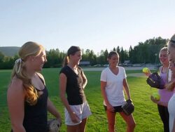 MS SLO MO Group of smiling female softball players tossing ball to each other after practice on field on summer evening Stock Footage