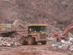 MS Excavator truck loading stone in another truck at quarry / Taben-Rodt, Rhineland-Palatinate, Germany Stock Footage
