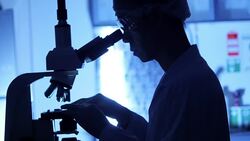 Scientist is using with microscope in dark Stock Footage