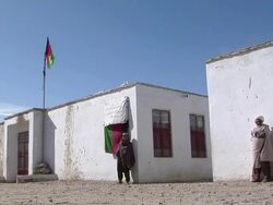 WS Afghan people entering building and police officer holding rifle / Mausa Qala, Helmand Province, Afghanistan. Stock Footage