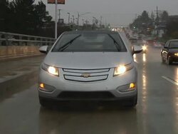 WS POV Electric car being driven in city traffic in rain / Rochester, Michigan, United States Stock Footage