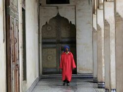 Male in traditional clothing walking in a beautiful ornate old Palace Fez, Morocco, Africa Stock Footage