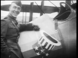B/W 1910s World War I flying ace Eddie Rickenbacker posing next to plane + smiling / doc. Stock Footage