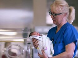 Female doctor holds a newborn baby Stock Footage