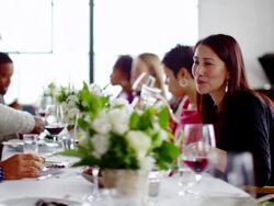 MS woman talking with friends at table during dinner party Stock Footage