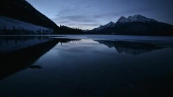 Time-Lapse of a mountain sunrise on a frozen alpine lake Stock Footage