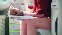 Reading a magazine in bathroom. Stock Footage