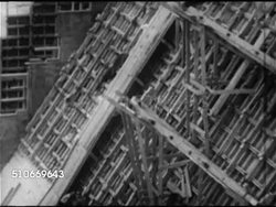 1952: CANADIAN BOOM: PUBLIC WORKS: WS TD Workers building, framing in large project, possibly dam. STEELE: WS HUGE Metal automated clamp picking up & moving large piece of metal. Natural resources, post-war economy. Instructional Video