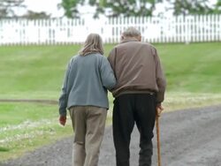 WS TD Senior couple walking arm in arm along dirt road / Washington State, USA Stock Footage