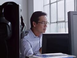 MS DS businessman sitting at desk in office of high tech startup looking at computer monitor Stock Footage